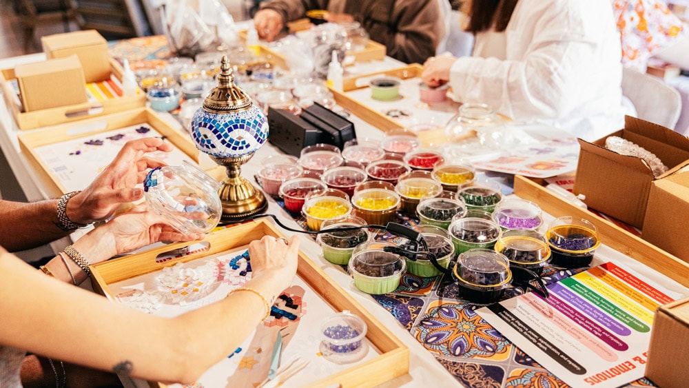 Lamp Decorating workshop at Tiles Workshop where participants create Turkish mosaic table lamps with colorful glass mosaic materials in a welcoming mosaic art studio