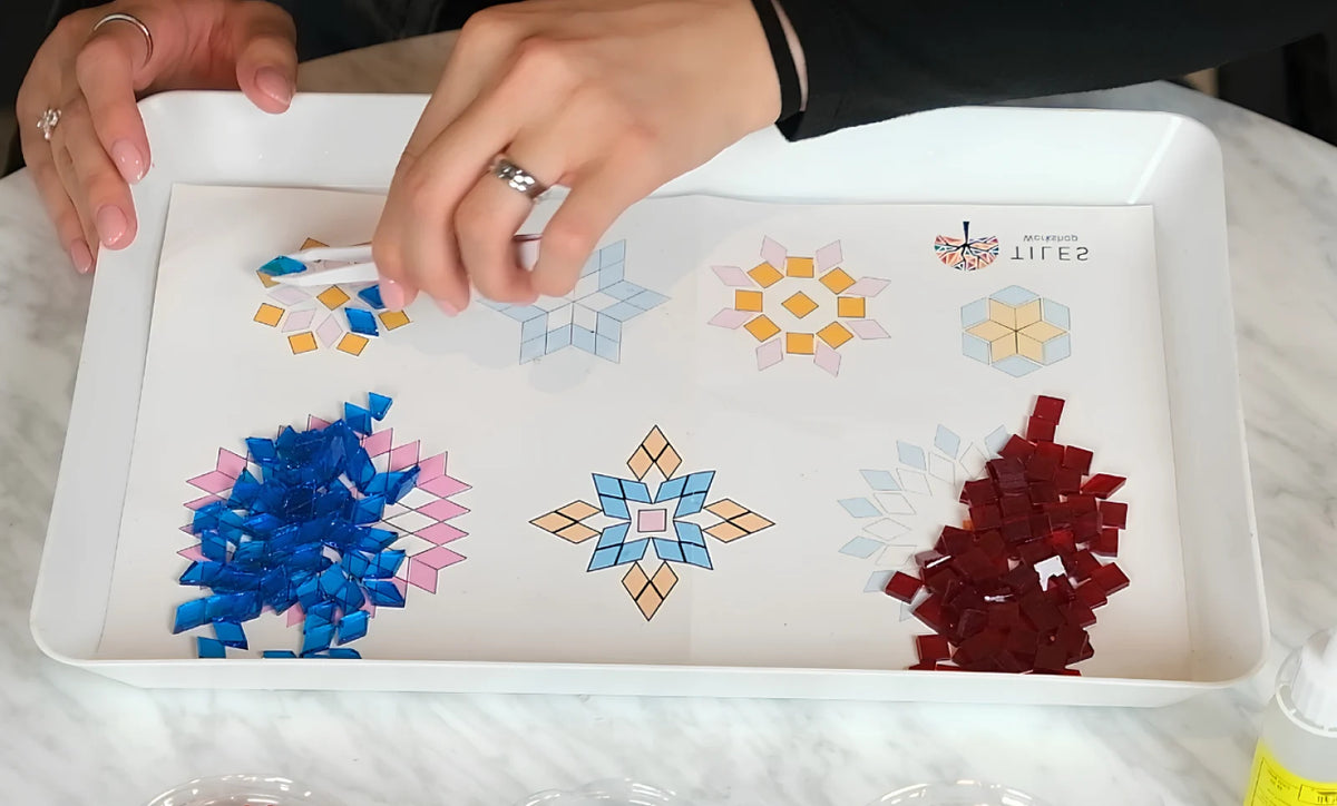Sorting colored glass pieces on a pattern sheet for a mosaic lamp